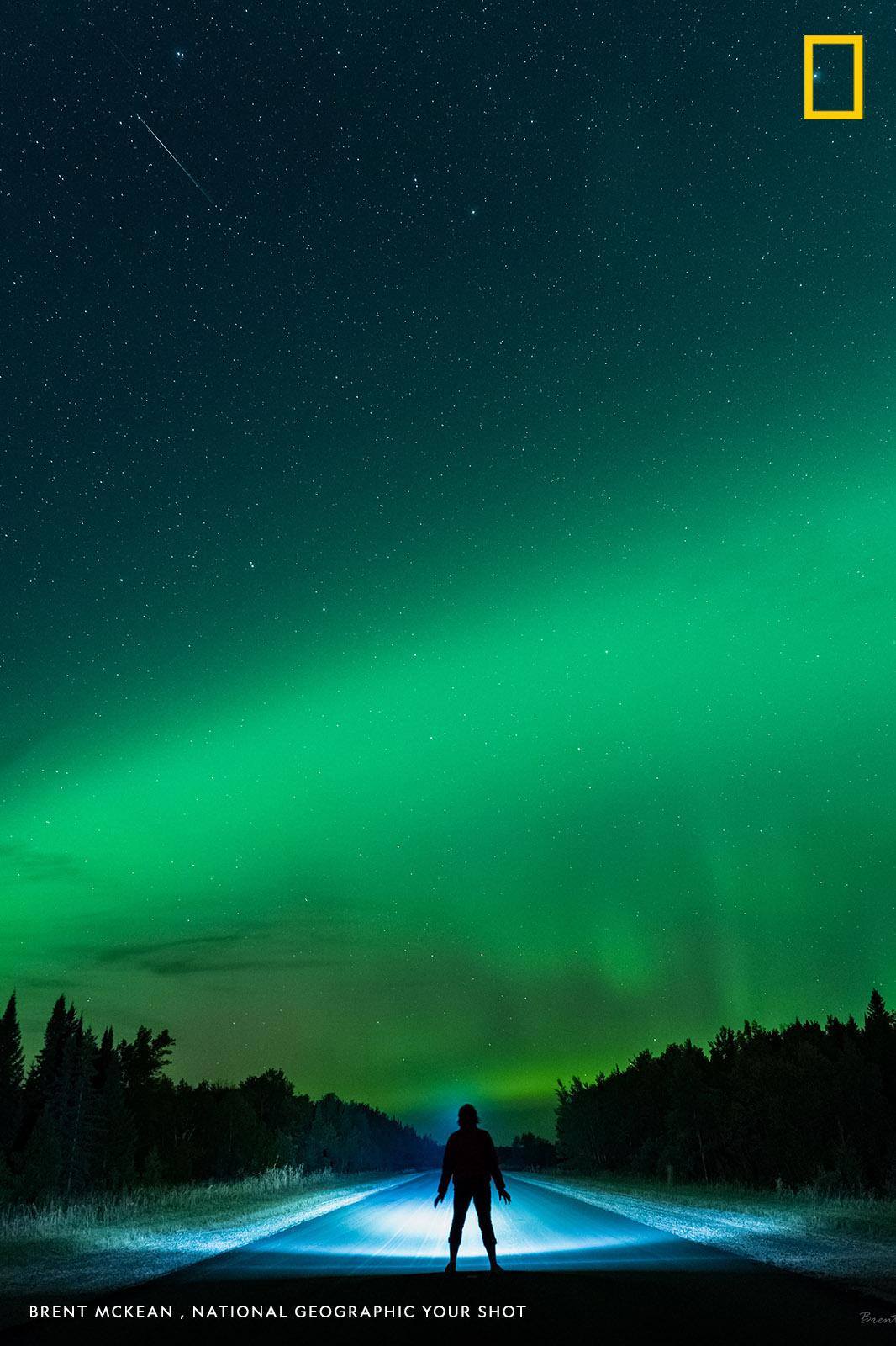 "On a warm September night, we ventured out to enjoy the night skies in Manitoba, Canada," writes photographer Brent McKean. "One of the other photographers was in the distance taking her shots, so I asked her to stand still to capture this shot with the aurora dancing in the background." https://on.natgeo.com/2QxSsTP